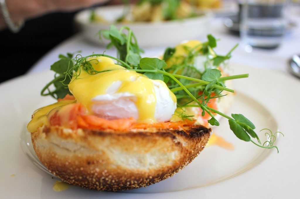 Golden hollandaise sauce drizzled over poached egg on toast